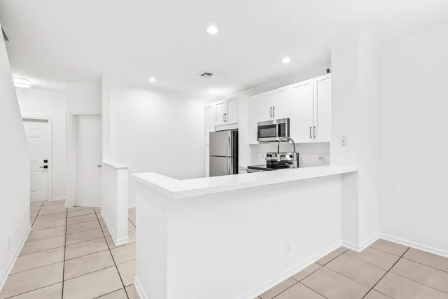 a kitchen with a refrigerator sink and cabinets