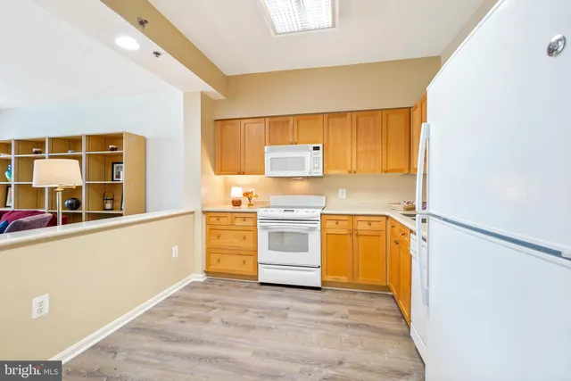 a view of a kitchen with wooden floor and electronic appliances