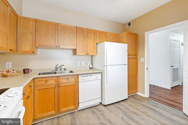 a utility room with wooden floor washer and dryer