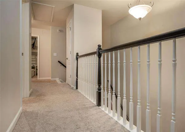 a view of a hallway with wooden floor and chandelier