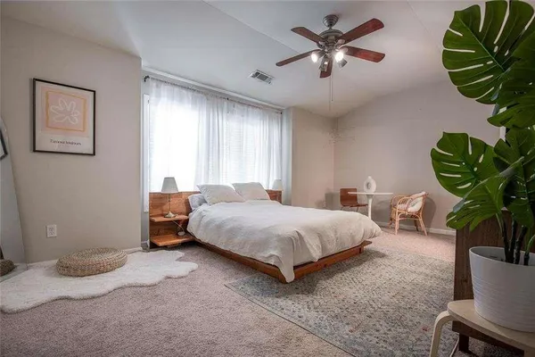 a bedroom with a bed a chandelier and a potted plant