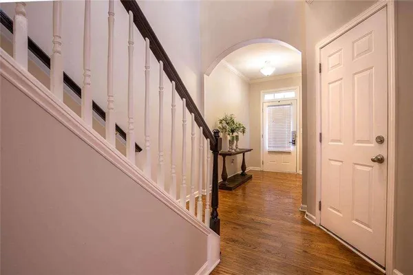 a view of a hallway with wooden floor and staircase