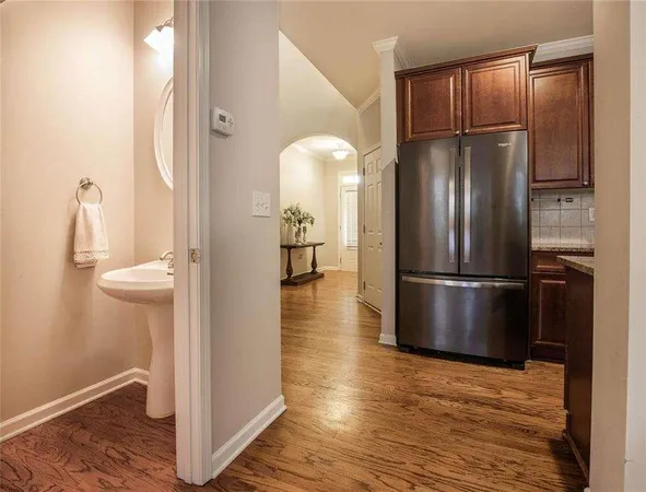 a kitchen with stainless steel appliances granite countertop a refrigerator and a wooden floor