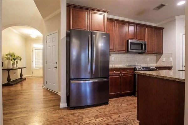 a kitchen with granite countertop stainless steel appliances and wooden cabinets