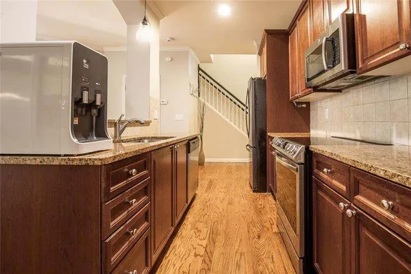 a kitchen with stainless steel appliances granite countertop a sink stove and refrigerator