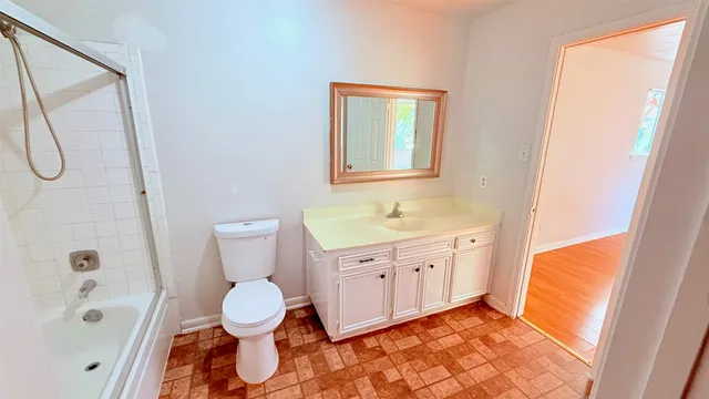 a bathroom with a sink a toilet and shower