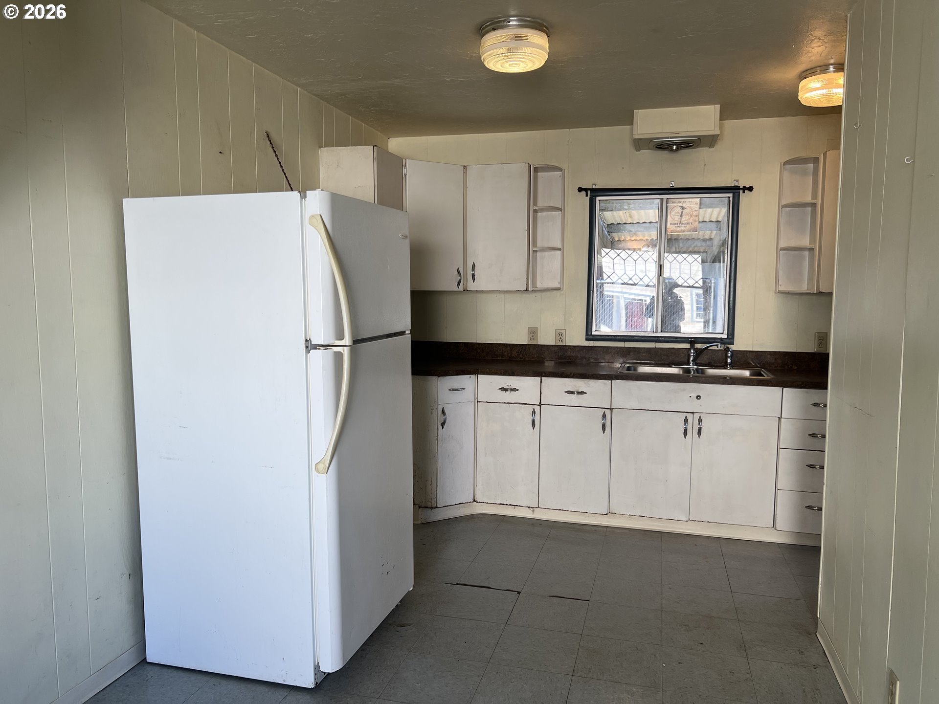 2260 Meade Avenue North Bend, OR 97459 - Photo 13 of 37 a kitchen with granite countertop a refrigerator a sink and white cabinets