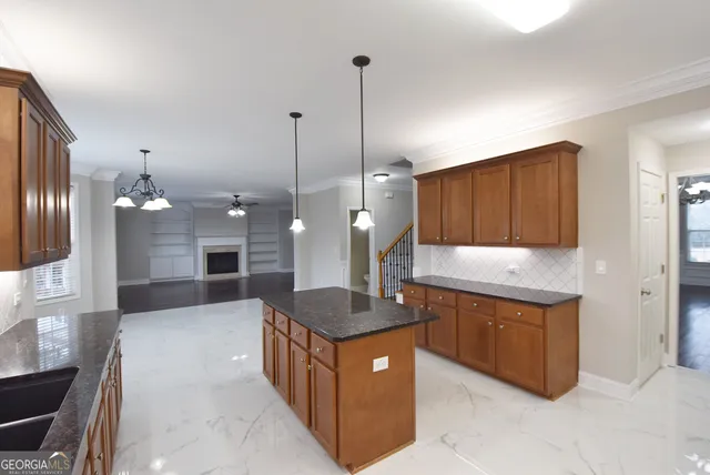 a large kitchen with granite countertop a sink and a wooden floor