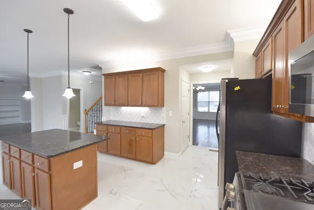 a kitchen with stainless steel appliances granite countertop a sink a stove and refrigerator