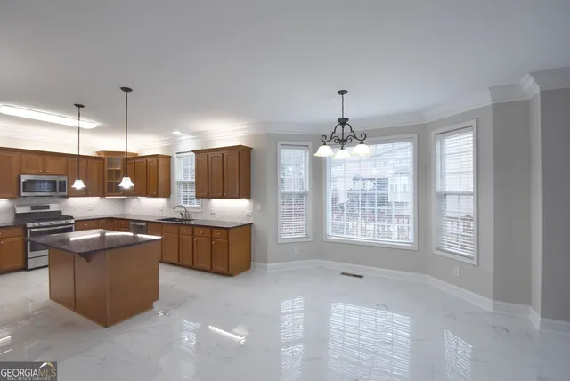 a view of an empty room with wooden floor and a ceiling fan
