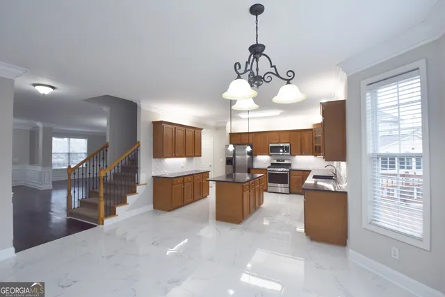 a view of an empty room with a fireplace and a ceiling fan