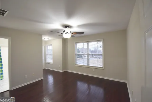 an empty room with wooden floor and window