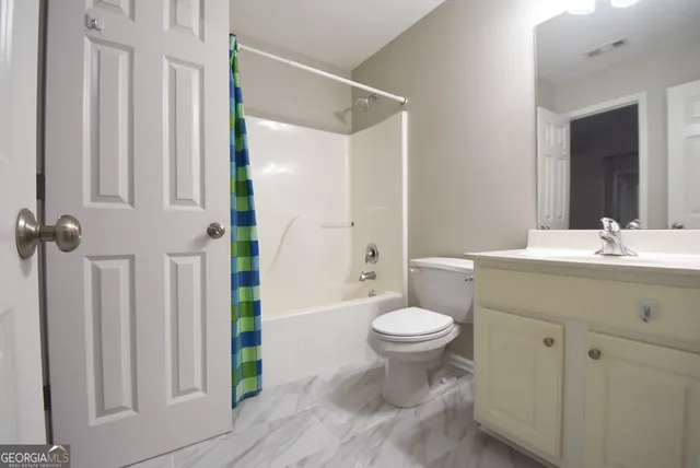 an empty room with windows and chandelier fan
