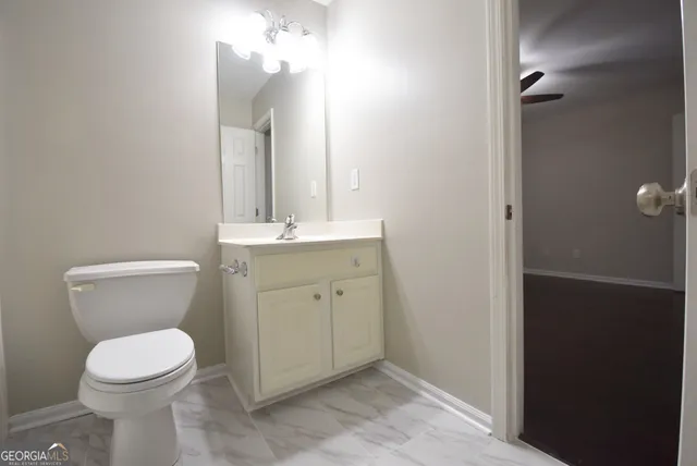 an empty room with wooden floor and fan