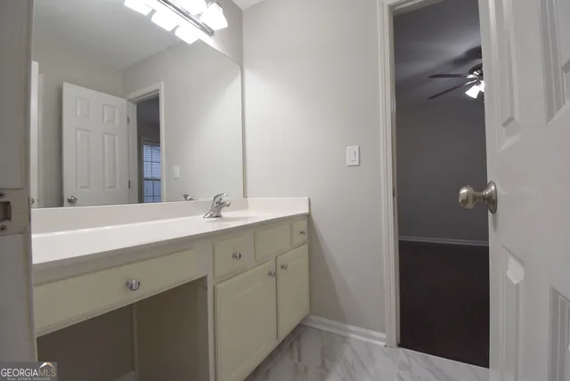 an empty room with wooden floor chandelier fan and windows