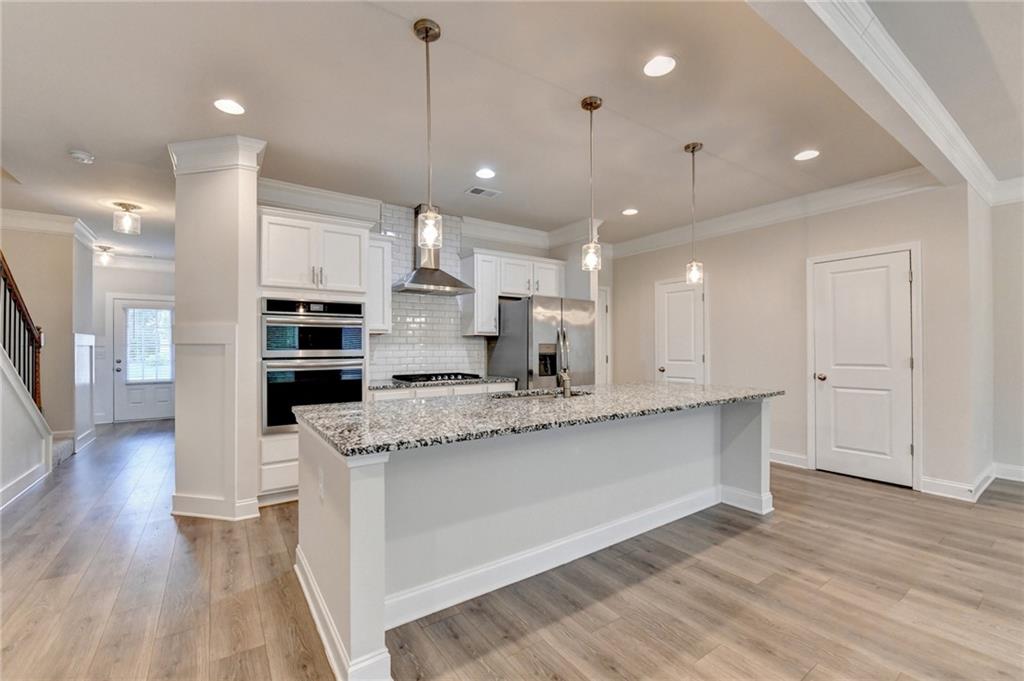 1431 Winding Rdg Trail Auburn, GA 30011 - Photo 31 of 53 a large kitchen with stainless steel appliances kitchen island a large counter top and a wooden floors