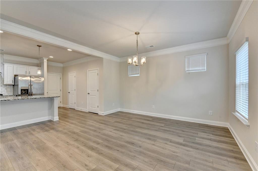 1431 Winding Rdg Trail Auburn, GA 30011 - Photo 7 of 53 an empty room with wooden floor and kitchen view