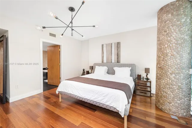 a bedroom with a bed and a chandelier