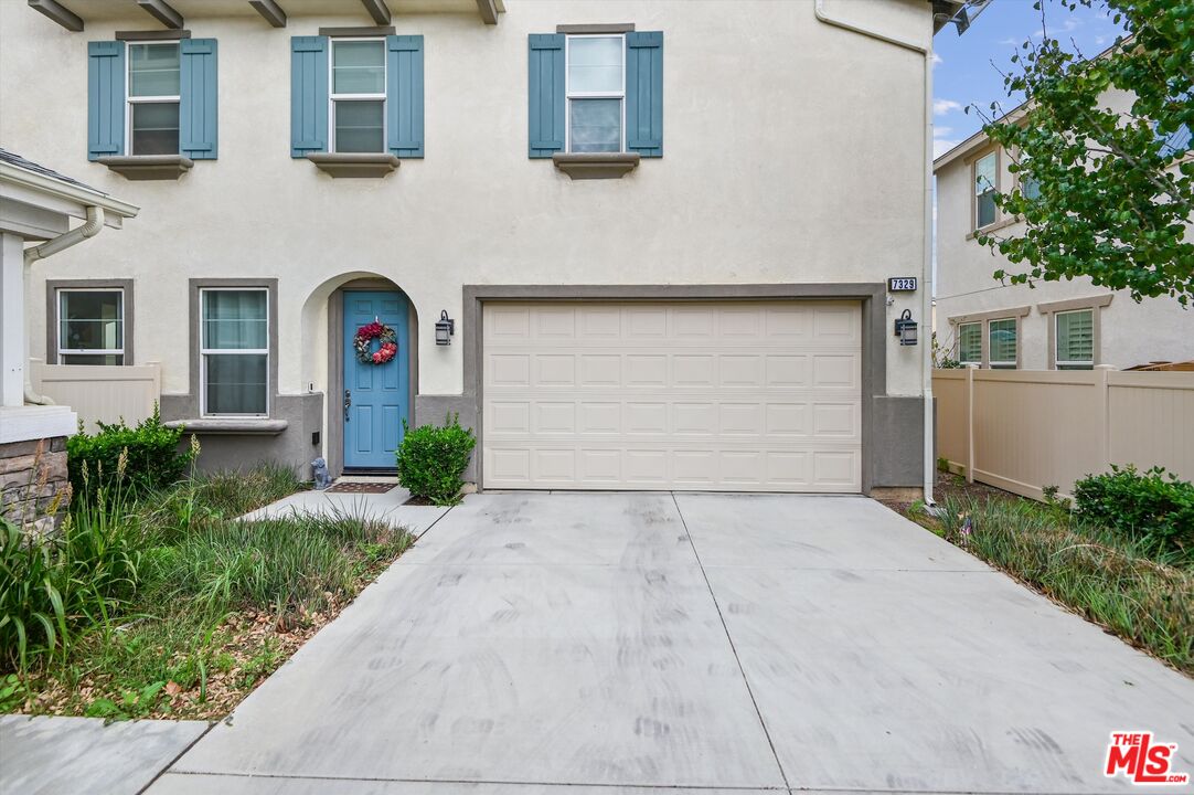 7329 Garnet Ridge Road Jurupa Valley, CA 92509 - Photo 3 of 35 a front view of a house with a yard and garage