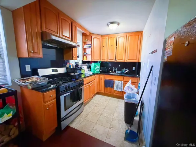 a kitchen with stainless steel appliances granite countertop a stove a sink and a refrigerator