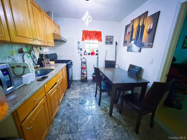 a kitchen with stainless steel appliances granite countertop a refrigerator a sink dishwasher and a dining table with the kitchen view