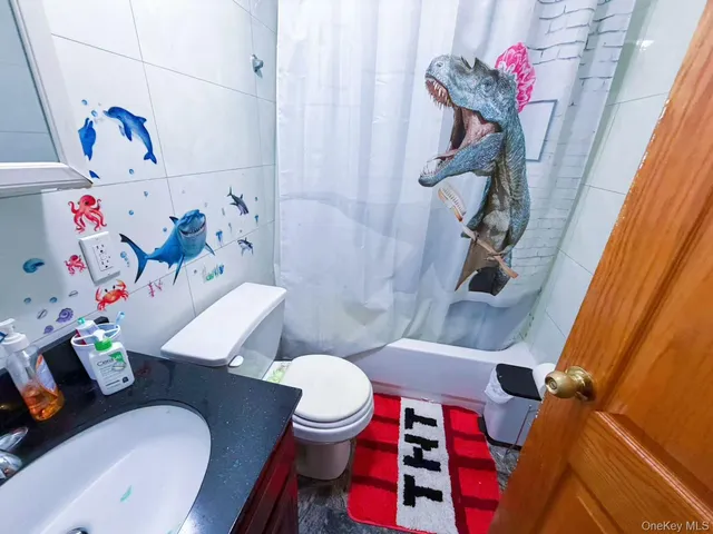 a bathroom with a sink toilet and shower curtain