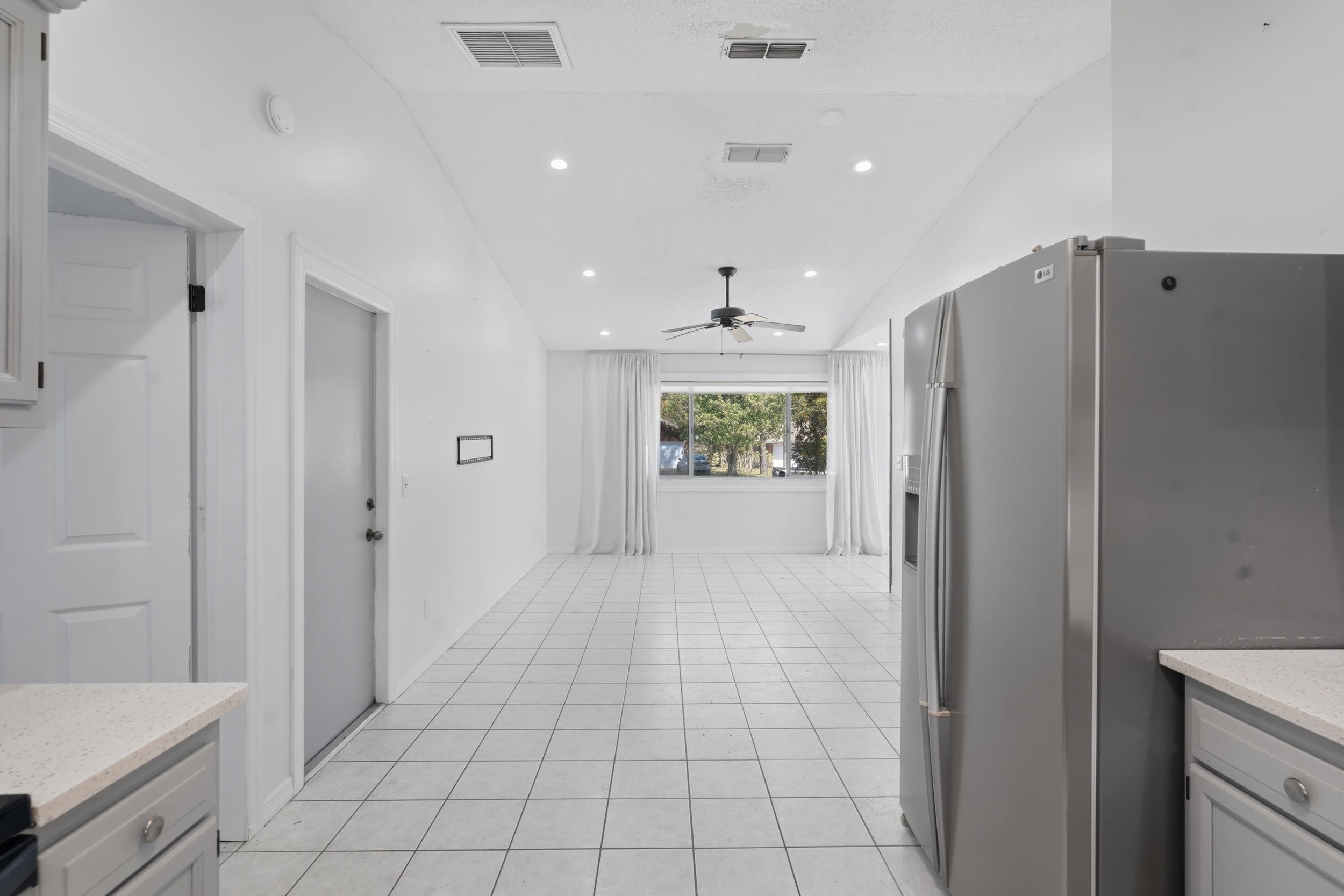 904 Alicante Road St. Augustine, FL 32086 - Photo 12 of 32 Kitchen with stainless steel fridge, light stone counters, lofted ceiling, gray cabinets, and recessed lighting