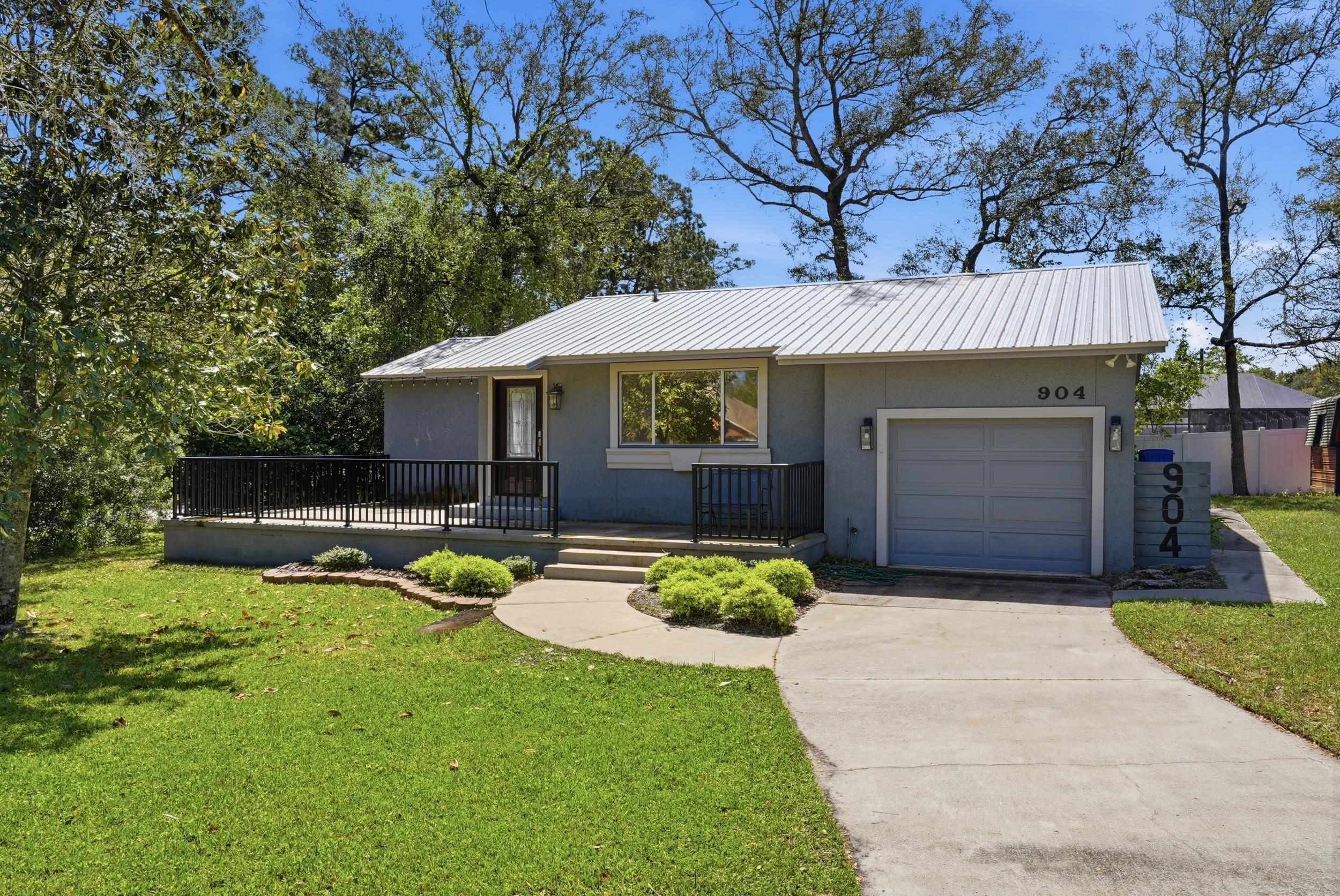 904 Alicante Road St. Augustine, FL 32086 - Photo 27 of 32 Ranch-style home with a front lawn, concrete driveway, a garage, stucco siding, and a metal roof