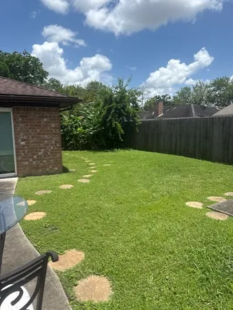 a view of house with backyard space and seating area
