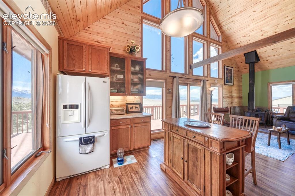 489 Excelsior Road Westcliffe, CO 81252 - Photo 12 of 34 a kitchen with stainless steel appliances granite countertop a refrigerator a stove and a dining table with wooden floor