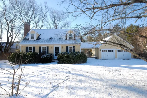 a front view of a house with a yard covered in snow