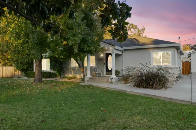 a view of a house with backyard and sitting area