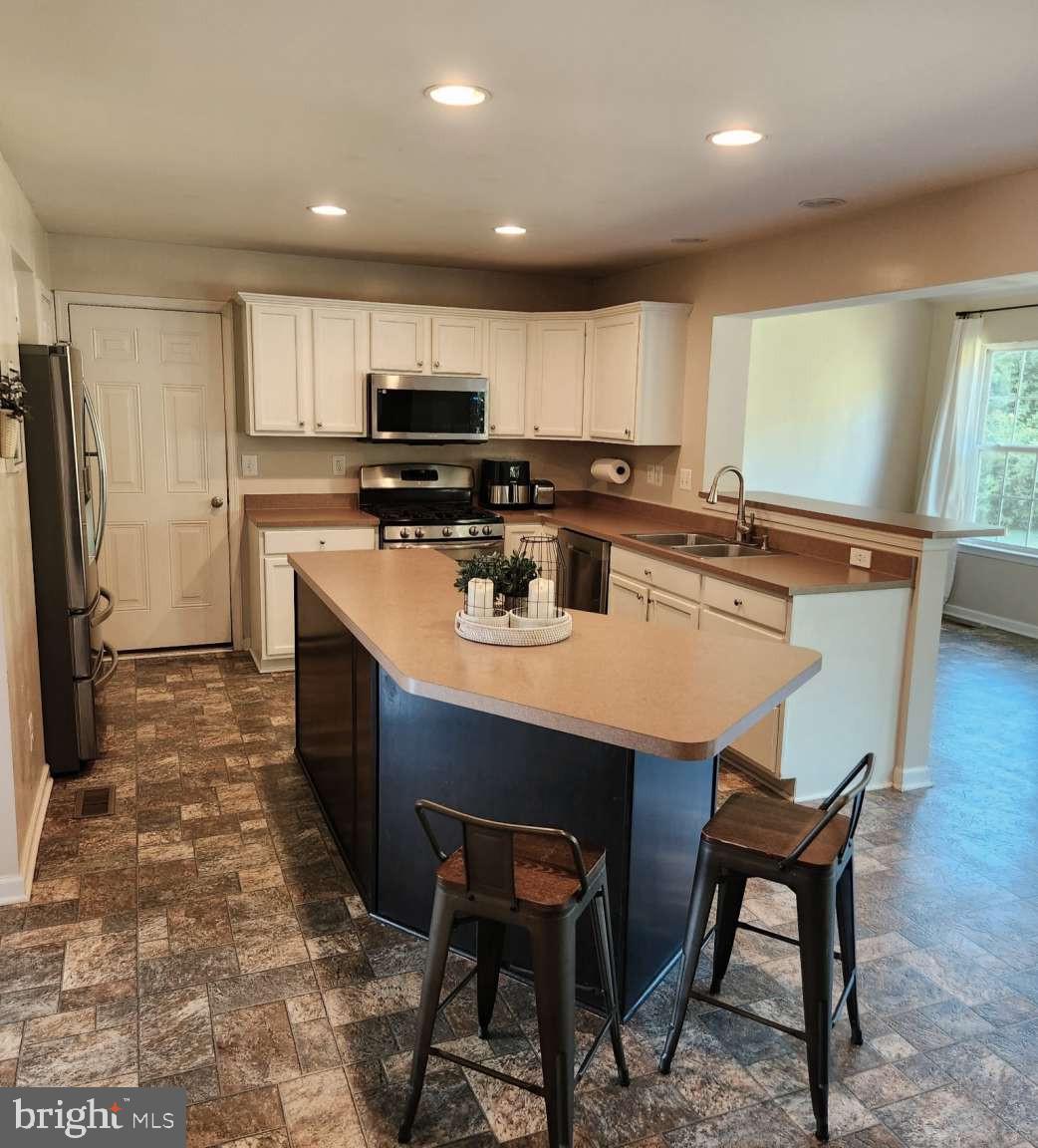 2040 Waterfall Drive Hanover, PA 17331 - Photo 5 of 25 a kitchen with stainless steel appliances granite countertop a stove a refrigerator a sink a dining table and chairs
