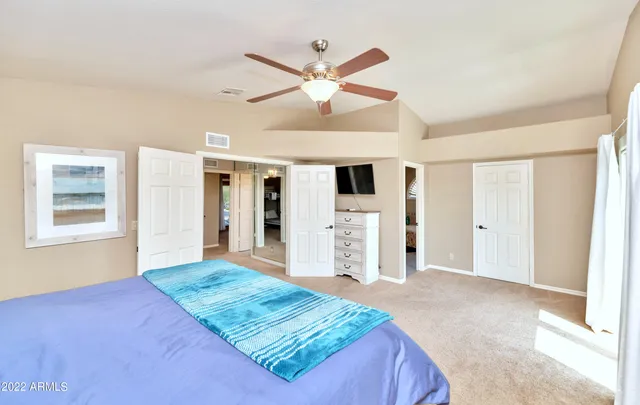 a spacious bedroom with a large bed and a chandelier