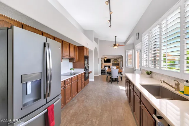 a kitchen that has a lot of cabinets a sink and appliances
