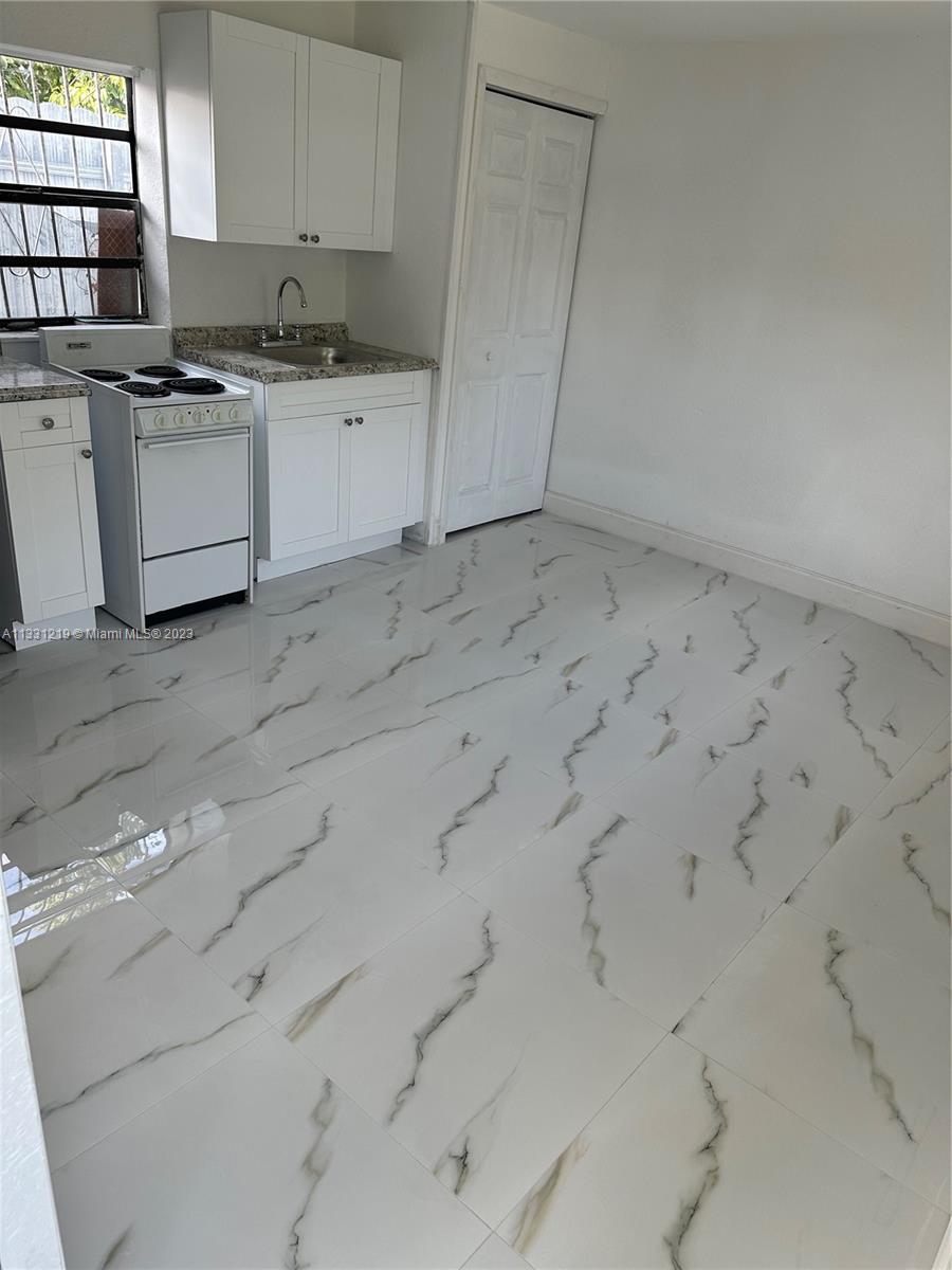 2625 Northwest 55th Street, Unit 3 Miami, FL 33142 - Photo 1 of 3 a kitchen with white cabinets