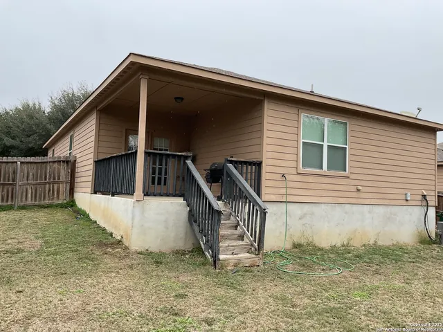 a view of a house with a small yard and wooden fence