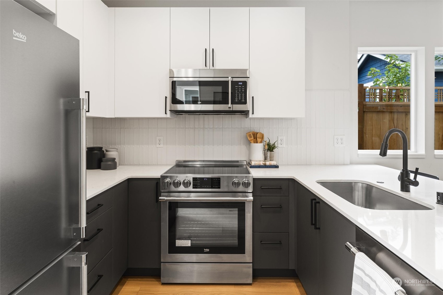 8021 17th Avenue Northwest Seattle, WA 98117 - Photo 6 of 23 a kitchen with stainless steel appliances granite countertop a sink stove and microwave