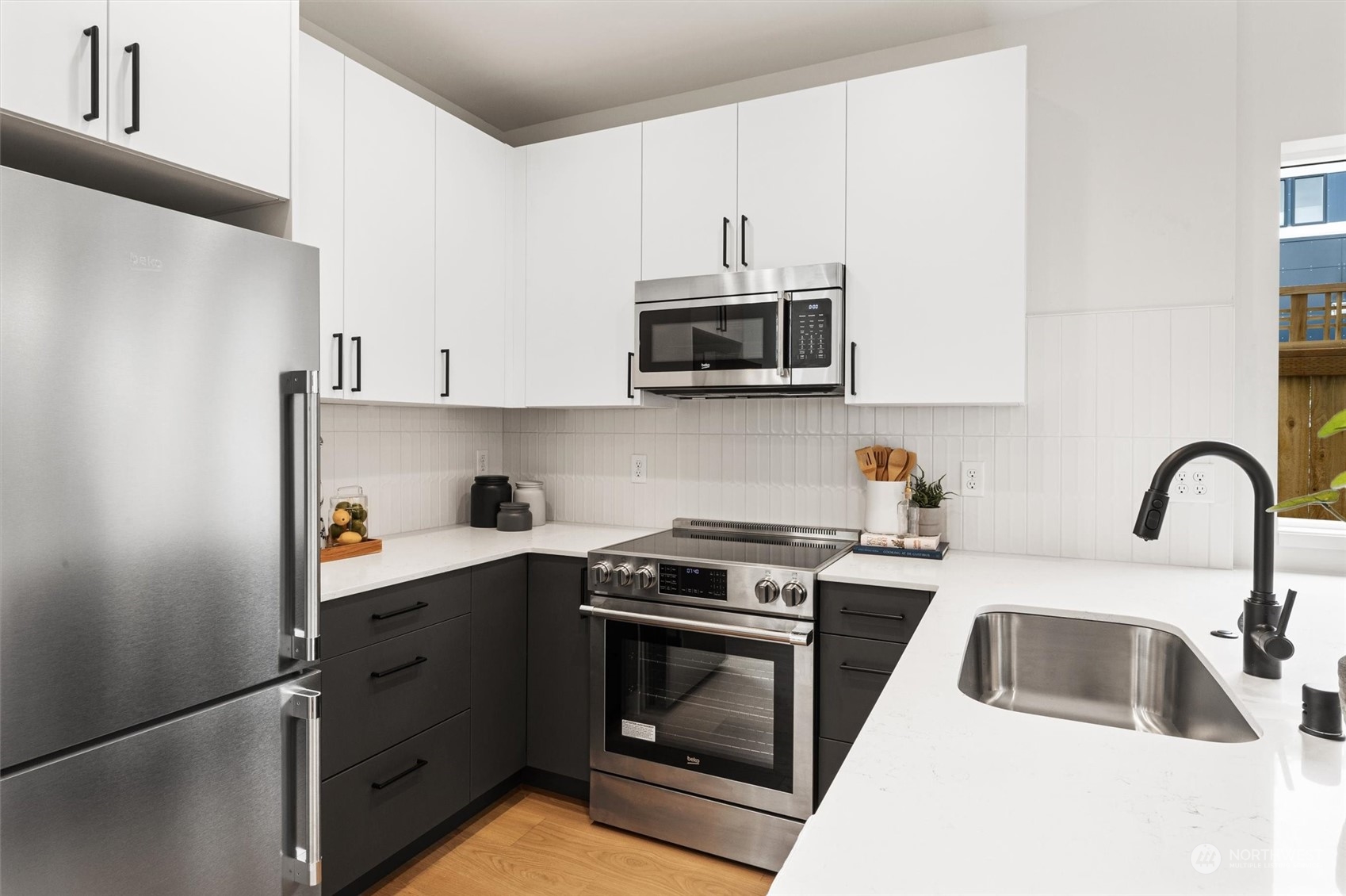 8021 17th Avenue Northwest Seattle, WA 98117 - Photo 7 of 23 a kitchen with stainless steel appliances granite countertop a sink stove and microwave