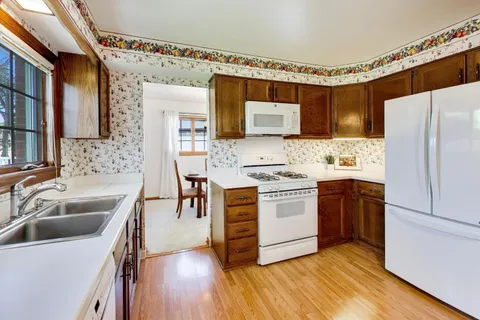 a kitchen with stainless steel appliances a sink cabinets and a wooden floor