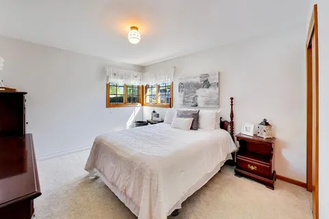 a large bed sitting in a bedroom next to a window