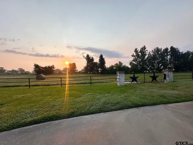 a view of a lake with a yard and large trees