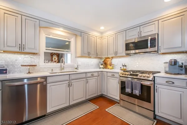 a kitchen with cabinets stainless steel appliances and a sink