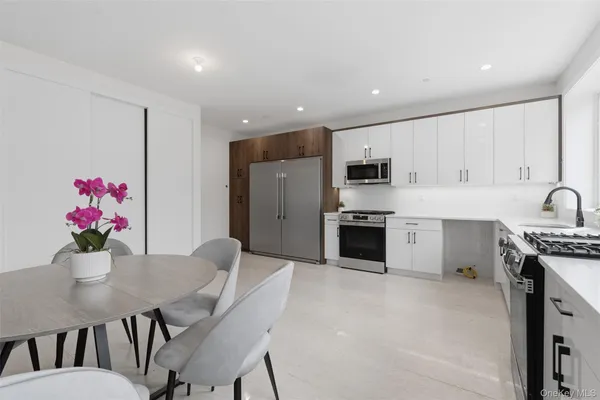 a kitchen with stainless steel appliances a stove a sink a microwave a refrigerator and cabinets