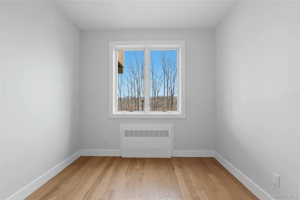 a view of a small space with wooden floor and a window