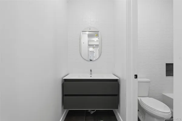 a bathroom with a sink toilet and a mirror