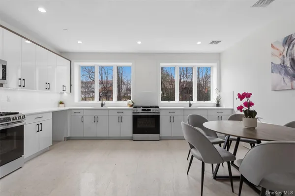 a kitchen with granite countertop white cabinets and stainless steel appliances