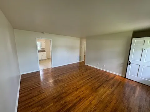 a view of empty room with wooden floor and fireplace