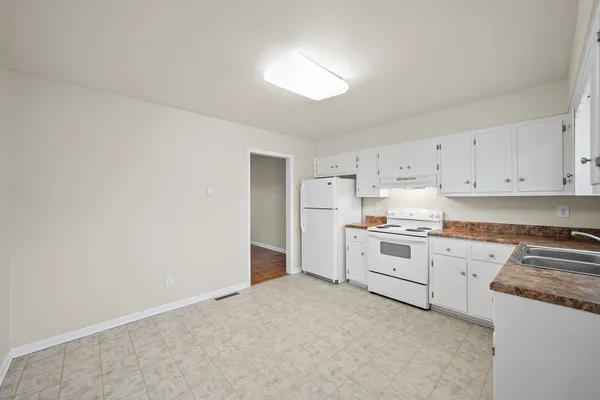 a kitchen with white cabinets and white appliances