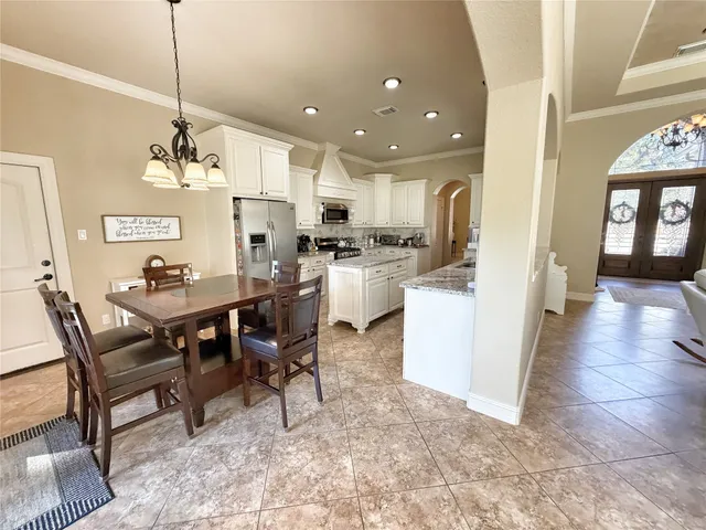 a kitchen with stainless steel appliances granite countertop a stove top oven a sink dishwasher and a refrigerator